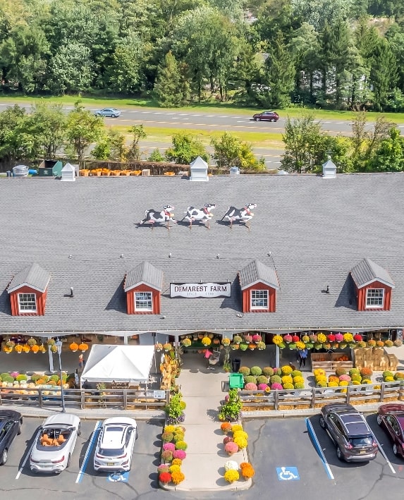 An aerial view of a demarest farms with cars parked in front, showcasing a bustling commercial hub.